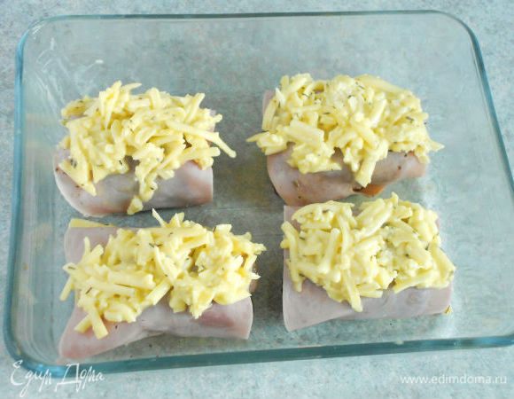 
Готовое филе положить в мелкое жаропрочное блюдо. Каждый ломтик ветчины разрезать пополам и обернуть ими филе, а сверху распределить сырную смесь.
Запекать в предварительно разогретой духовке (электрическая 200 ° C / с конвекцией 175 ° C / газ  3) до золотистого цвета около 12 минут. 