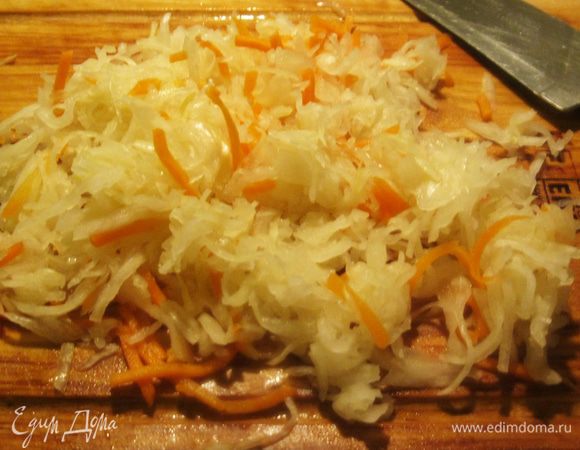 Большую жмень квашеной капусты, примерно 300 грамм, разложил на доске и порубил помельче.