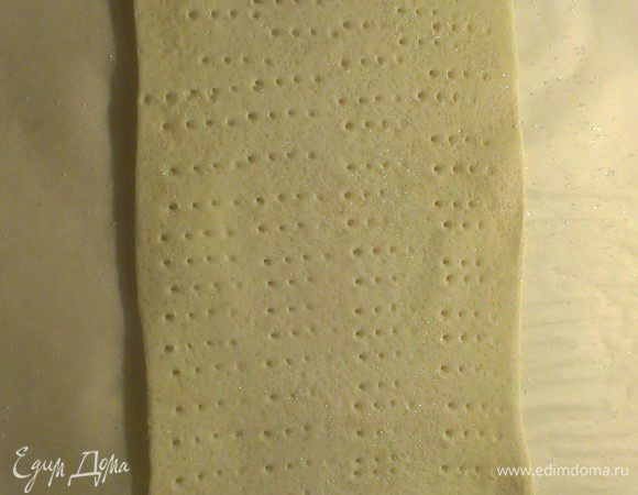 Наколите вилкой тесто, смажьте желтком и отправьте его в разогретую до 200° С духовку до момента, когда поверхность станет золотистой.
