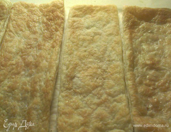 Переверните пласты теста на другую сторону, наколите их вилкой, чтобы поднявшееся слоеное тесто опустилось, и отправьте опять в духовку до "золотистой корочки".