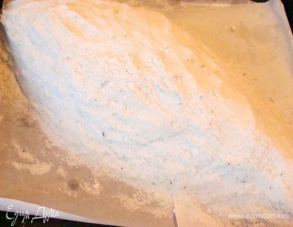 Выложить соль сверху рыбы, так, чтобы она покрывала ее со всех сторон на 1.5 см толщиной (слой соли).