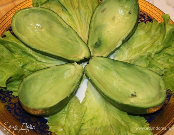 Лодочки из авокадо выложить на листовой салат и наполнить их начинкой. Украсить физалисом, креветками и половинками перепелиных яиц.