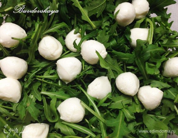 Моцарелу вынуть из рассола и выложить сверху на руколу.