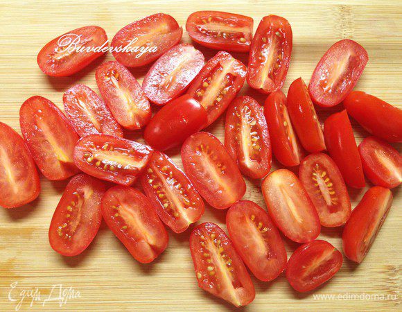 Помидорки черри вымыть, обсушить, разрезать напополам и выложить  в салатник.