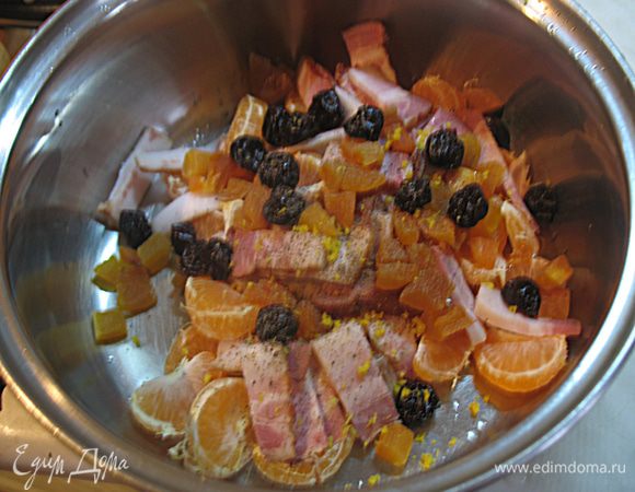 Готовим начинку для курицы. В миске смешиваем 4 мандарина разделенных на дольки, цукаты, порезанный на полоски бекон. Добавляем пару ложек оливкового масла, молотого черного перца, цедру лимона и перемешиваем. 