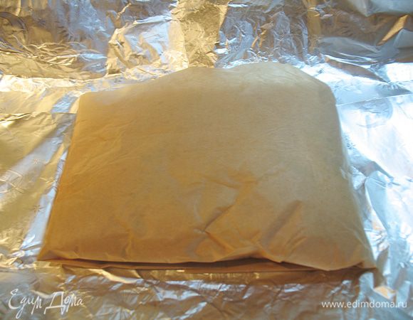 Перекладываем курицу в пергаменте на фольгу и плотно заворачиваем ее. 
