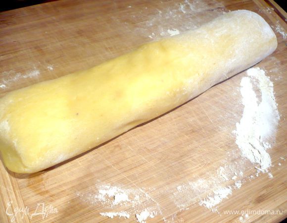 Раскатать его на припыленной мукой поверхности в колбаску, разделить ее на 9 равных частей. 