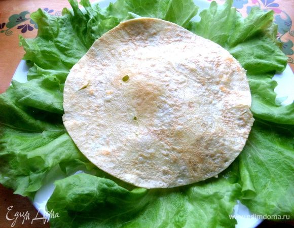 Тонкий омлетик обрезаем и кладём как основу салата.