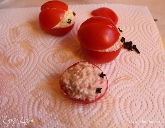 Наполняем наши помидоры рaзными начинками. Глазки делаем из гвоздики. Крылышки из половинок помидор кладём сверху. И рисуем майонезом точки. Готовые "Божьи коровки" выкладываем на блюдо с зеленью.