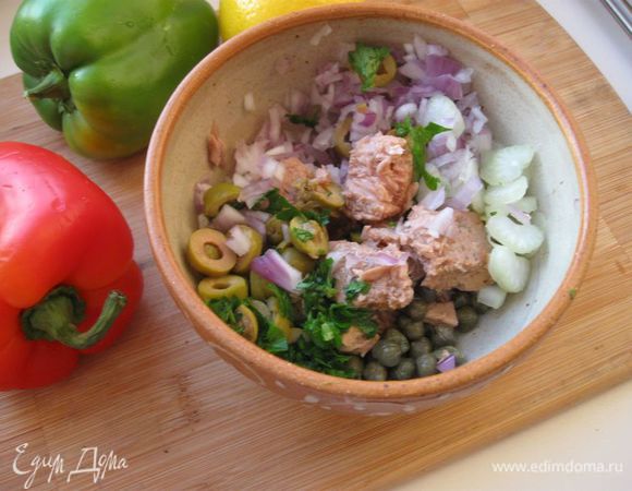 У перцев срезать верхушку и аккуратно вычистить их изнутри, освобождая от семян и перегородок.
 Тунца  размять вилкой. Оливки нарезать тонкими колечками. Лук, петрушку мелко порубить и добавить к тунцу, каперсам и оливкам. 
