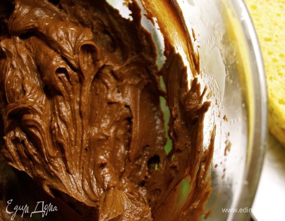 Оставшееся масло взбить с сахарной пудрой, ванилином и 3 ст.л. горячей воды. Добавить растопленный шоколад и перемешать. 