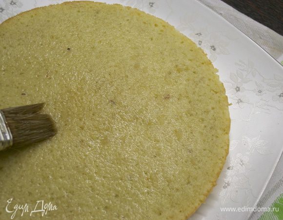 Приготовить сироп для пропитки, поставив на небольшой огонь воду с сахаром. Довести до кипения и немного уварить сироп. Снять с огня, остудить и добавить ром (или коньяк). Первый корж выложить на сервировочное блюдо и пропитать сиропом (1/3 его частью).