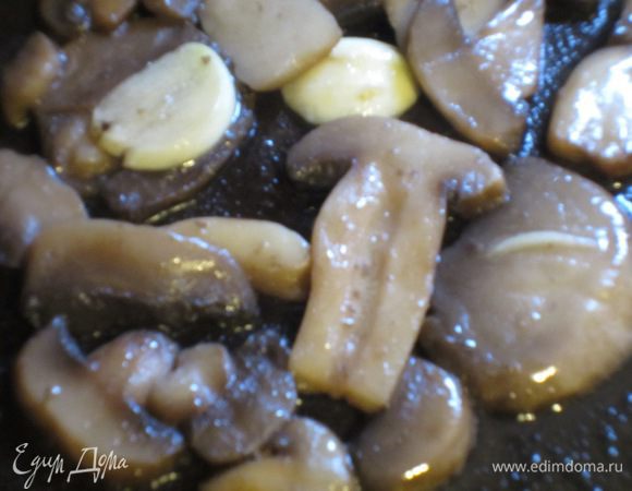 Грибы нарезать пластинками. Можно взять шампиньоны + белые грибы. В сковороде разогреть оливковое масло с зубчиком чеснока, добавить грибы, посолить, поперчить, накрыть крышкой и готовить 10 -15 минут. Чеснок удалить.