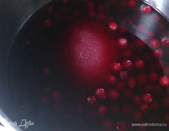 Смешать в ковшике клюкву, сахар и вино.