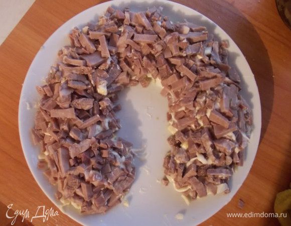 Порезать соломкой вареный язык и выложить поверх яиц. Смазать майонезом.