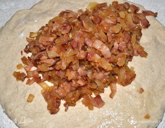 На блин выкладываем остывший бекон. Начинаем месить и вмешивать начинку.