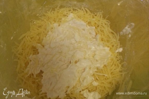 Выстилаем чашу пищевой пленкой, так чтобы края свисали. Выкладываем первый слой - твердый сыр, тертый на средней терке. Выкладываем столовую ложку чесночного майонеза.