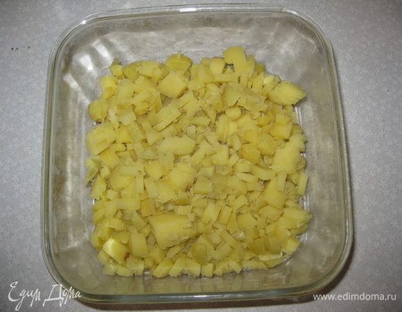 На дно выкладываем тонким слоем оливковый майонез "Слобода".
Чистим отварной картофель в мундире. Режим его квадритиками и выкладываем 1-й слой.