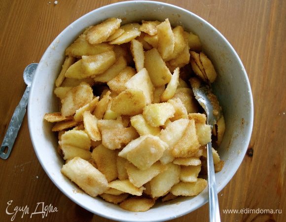 Смешать крахмал, сахар и специи. По рецепту берем 1/8 ч.л. мускатного ореха (в таблице ингредиентов указала 1 щепотку...)))) Присыпать яблоки и как следует перемешать, позволяя специям равномерно покрыть кусочки яблок.