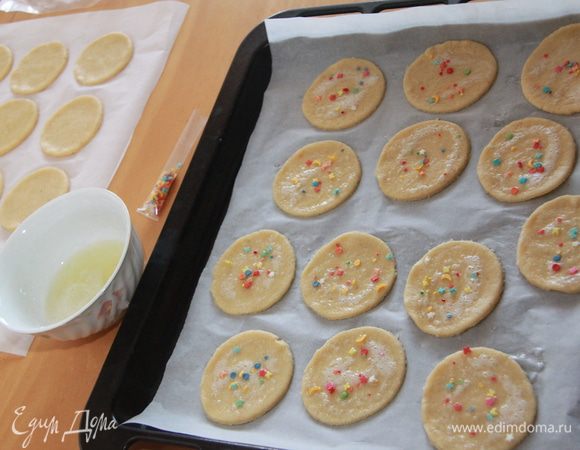 Выложить заготовки печенья на бумагу для выпечки. У меня получилось 26 печенюшек диаметром 7,5 см. Сверху смазать печенье яичным белком, слегка взбитым с солью и сахарной пудрой. Украсить кондитерской посыпкой. Выпекать при 180*С 8-10 минут.