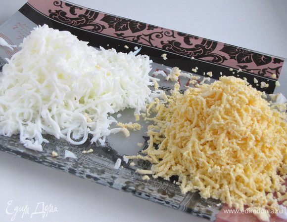 Отварные яйца почистить, отделить белки от желтков и натереть на мелкой терке.