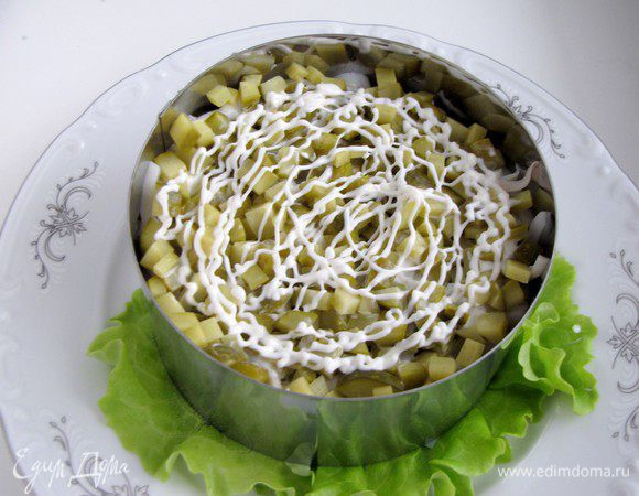 Потом груша. На грушу снова выложить кальмары. Сверху маринованные огурцы.