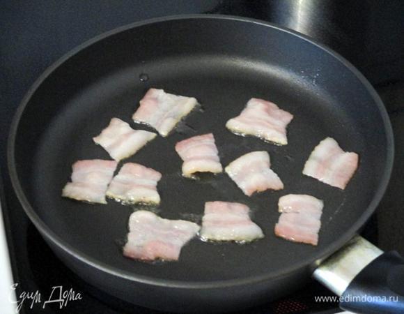 Нарежьте бекон квадратными кусочками и на среднем огне на небольшом количестве растительного масла обжарьте и подсушите.