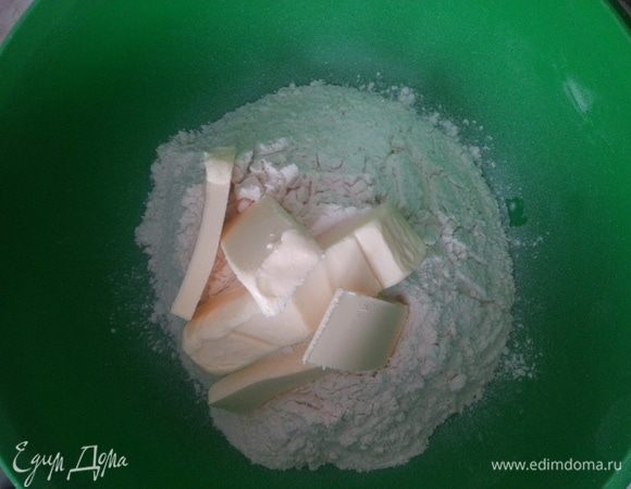 Просеиваем в чашу муку, добавляем сахар и ледяное сливочное масло, нарубив его кусочками...