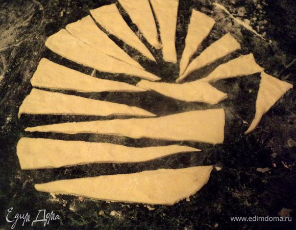 Часть теста раскатать толщиной 4 мм и вырезать удлиненные треугольники.