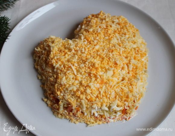 Сверху рыбы - тертые белки. Далее смешаем желтки с сыром и выкладываем сверху. Немного сыра оставим для украшения. И сеточка из майонеза.