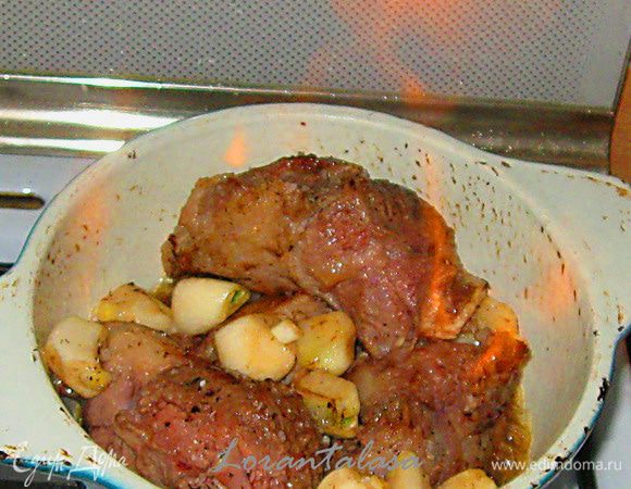 Вылить коньяк. Поджечь его с помощью деревянной шпажки. Через минуту добавить немного воды . Накрыть крышкой. Уменьшить огонь. Тушить в течении 2,5 часов.