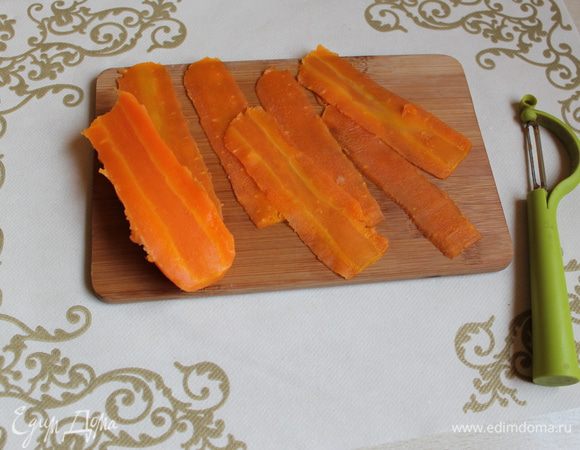 Морковь почистим и нарежем на плаcтинки овощечисткой. Лишнее нарежем на кубики.