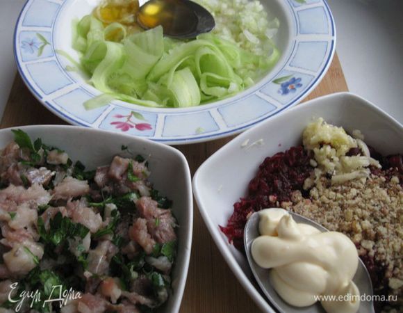 Добавить мед в яблочно-огуречную смесь. Майонез – в свеклу. Сельдь измельчить. Петрушку помыть, мелко порезать, добавить в селедку.