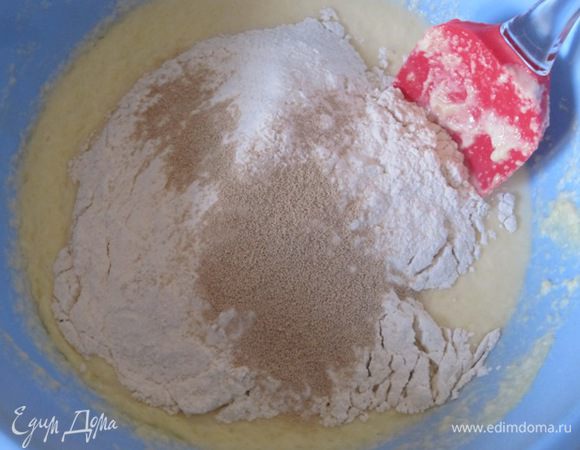 Постепенно всыпать муку, смешанную с сухими дрожжами.