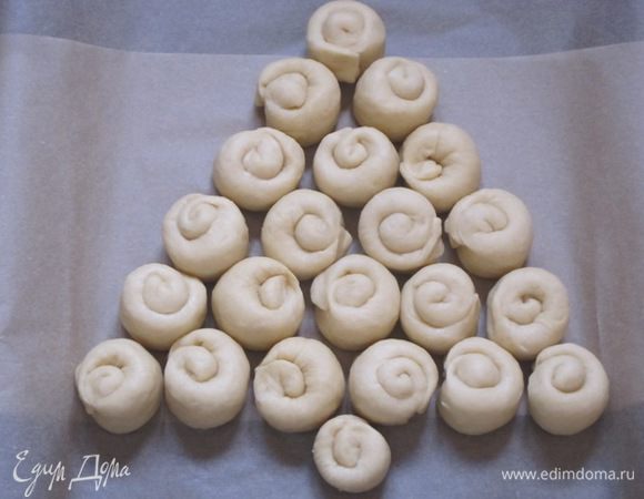 Выложить на противень, выстланный бумагой для выпечки, на небольшом расстоянии друг от друга в виде треугольника - "ёлочки".