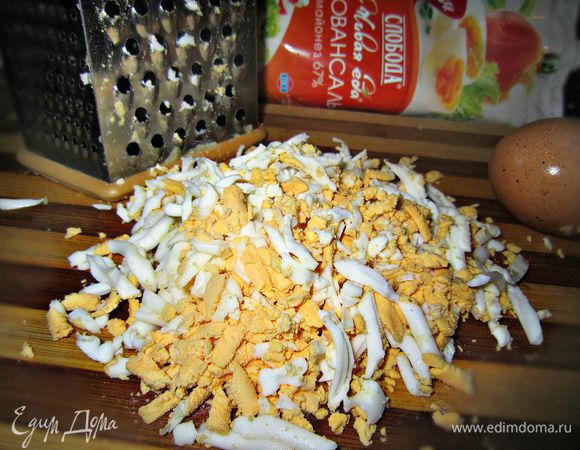 Яйца чистим, натираем на крупной тёрке и выкладываем поверх лука. Смазываем немного майонезом.