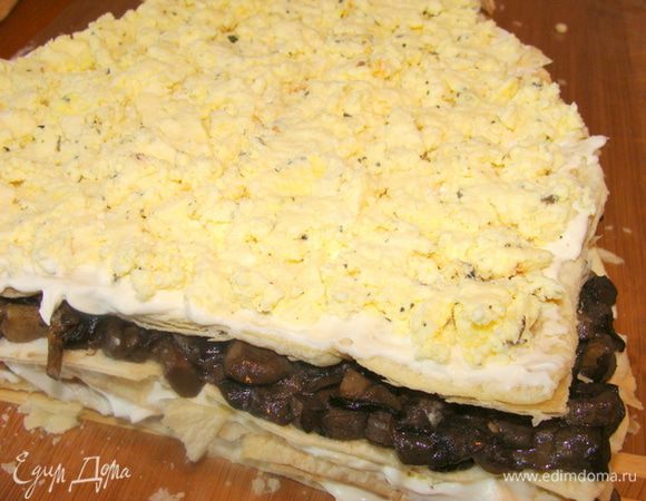 Сверху четвертый корж теста, придавить, помазать майонезом и распределить  вторую половину сыра.