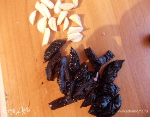 Порезать чернослив и чеснок так, чтобы было удобно шпиговать мясо.