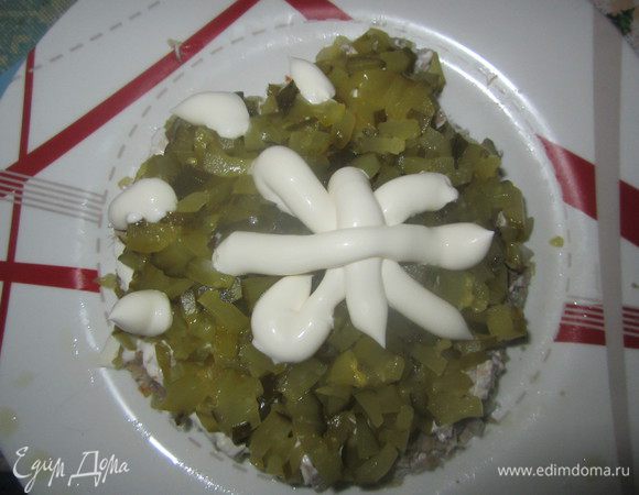 Мелко порезать соленые огурцы, выложить следующим слоем и промазать майонезом.