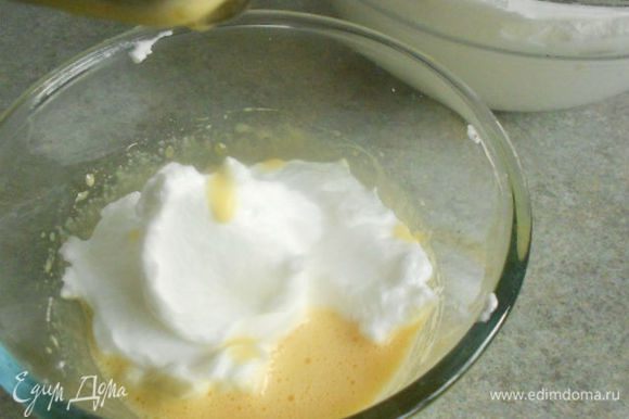 В отдельную миску положите желтки, ванильный сахар и взбейте до светлой массы, затем добавьте 3 ст.л. взбитых белков, муку, цедру и хорошо взбейте до вполне густого крема.