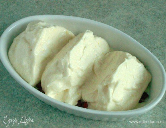 Полученный крем добавьте частями в оставшуюся белковую смесь. Перемешивайте лопаткой складывающими движениями снизу вверх и не старайтесь получить слишком уж гомогенную массу.
Переложите яичную массу в горячую форму в виде трёх высоких горок. Удобнее всего это делать широким кулинарным скребком, на нём как раз умещается 1/3 массы.