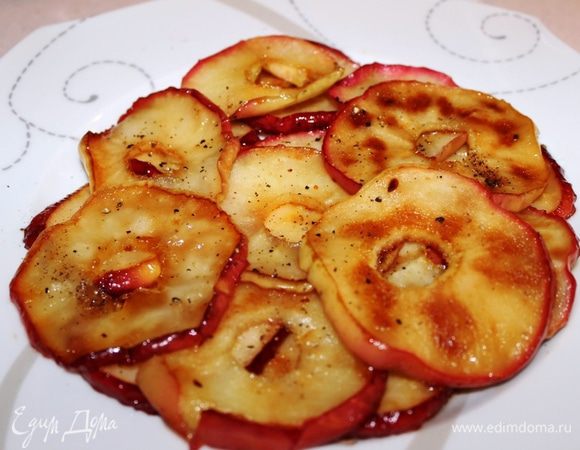 Пока гусь запекается приготовить для подачи карамелизованные яблоки: вынуть из них сердцевину, нарезать кругляшками, поджарить на сковороде в сливочном масле и сахаре, присыпать перцем