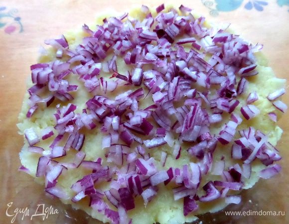 Половину красной луковицы очень мелко крошим вторым слоем и поливаем маслом из баночки с печенью.
