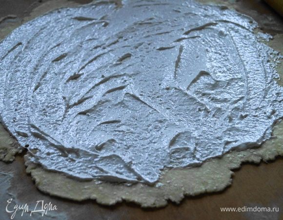 Тесто разделить на 2 части. Раскатать 1 часть в тонкий пласт, смазать половиной безе.