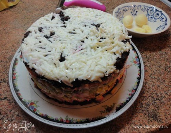 Кольцо от разъемной формы диаметром 18-19 см уложить на блюдо и выложить с него все ингредиенты слоями, смазывая каждый майонезом, в следующей последовательности: свекла, яблоки, картофель, соленые огурцы, морковь, чернослив. Яичные белки натереть на крупной терке и выложить на чернослив. Верх и бока смазать майонезом и верх торта посыпать натертыми на мелкой терке яичными желтками. Бока украсить рублеными орехами, а верх цветами из овощей, входящих в состав салата.