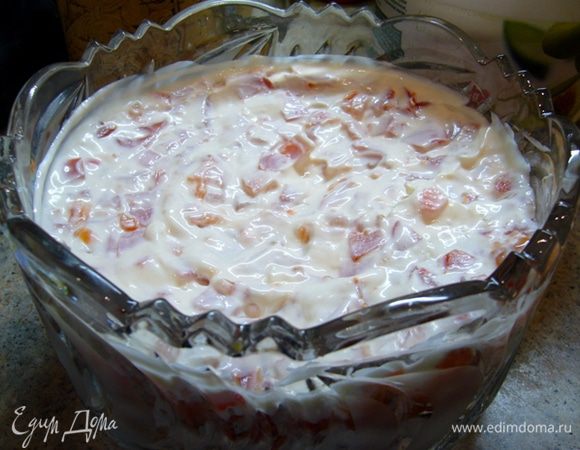 Третьим слоем выкладываем порезанные на кубики помидоры. Причем сок сохранить не стараемся, чтобы салат держал форму и не был водянистым. На помидоры снова нанести слой майонеза.