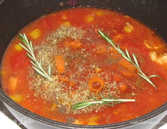 Добавить в кастрюлю помидоры вместе с соком, зиру, орегано, розмарин ( у меня свежий), соль и черный перец. Влить 200 мл. холодной воды. Довести до кипения, убавить огонь до минимального и готовить под крышкой 1 час. Время от времени помешивайте.