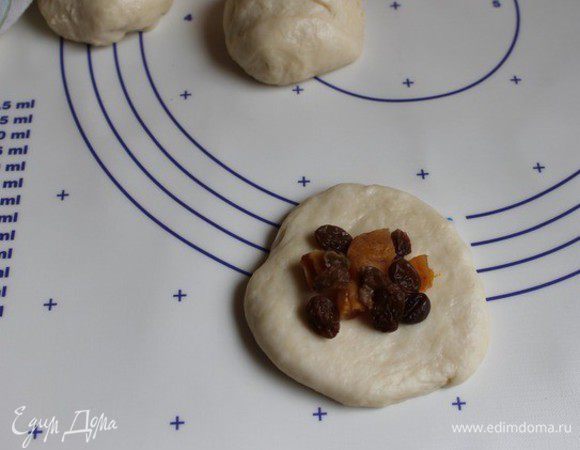 Тесто подошло. Разделим его на 15-16 частей. Сформуем колобочки и дадим минут 10-15 полежать им под полотенцем. Далее берем колобок, раскатываем его слегка, не тонко. Кладем начинку на середину. Сахар не добавляем. Можно взять другую начинку, не сладкую, например яйцо с луком.