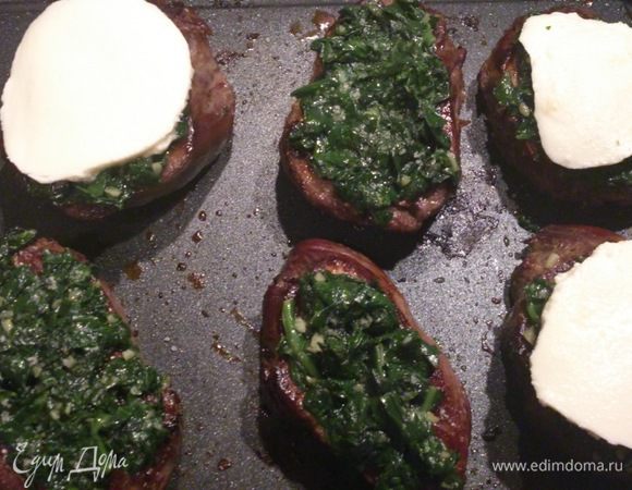 Медальоны слегка посолить, выложить на них шпинат и накрыть его порезанной на шайбы моцареллой.