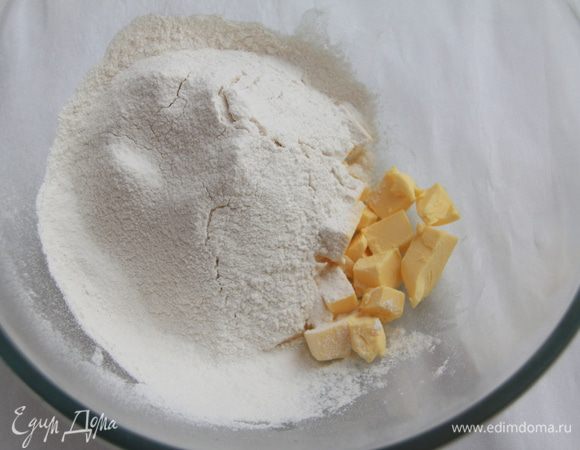 Муку просеять и соединить с размягчённым сливочным маслом, перетереть смесь в крошку.